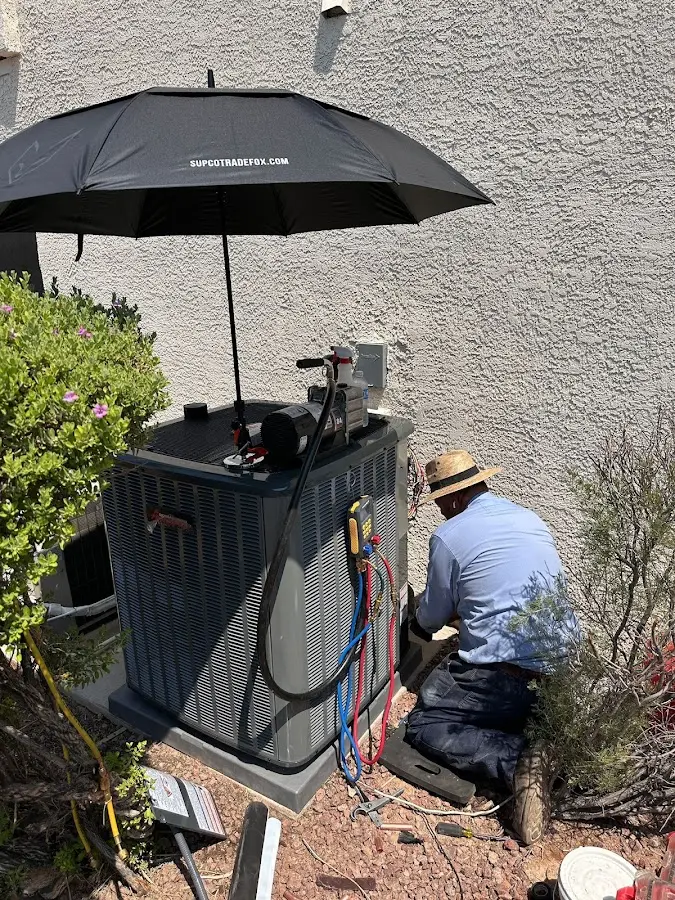 HVAC technician performing outdoor AC maintenance in Tipton